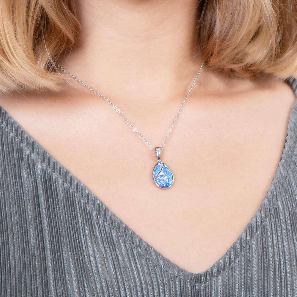 The picture shows a model wearing a 925 sterling silver pieces of opalite gems teardrop pendant with cubic zirconia.