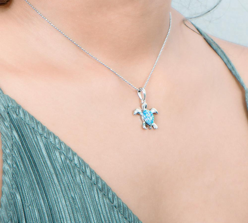 The picture shows a model wearing a 925 sterling silver opalite sea turtle pendant.