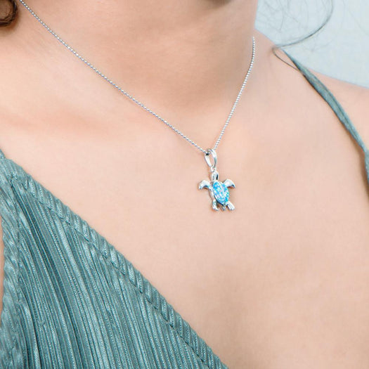 The picture shows a model wearing a 925 sterling silver opalite sea turtle pendant.