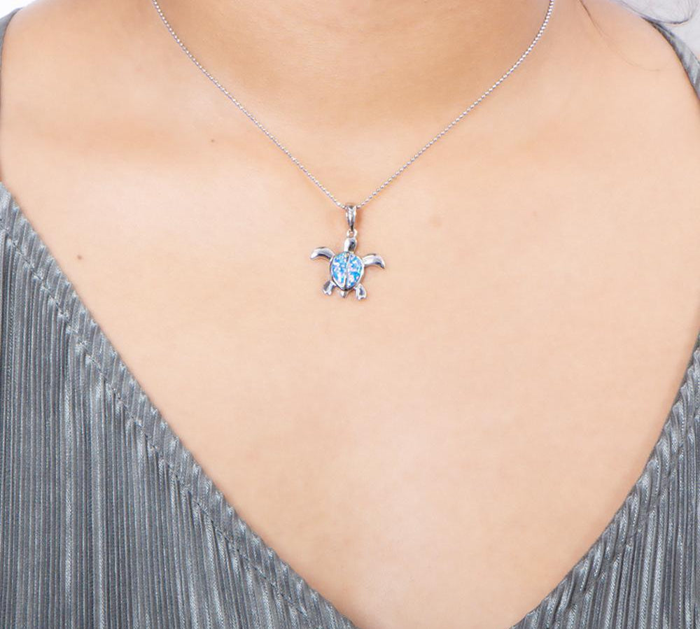 The picture shows a model wearing a 925 sterling silver opalite sea turtle pendant.