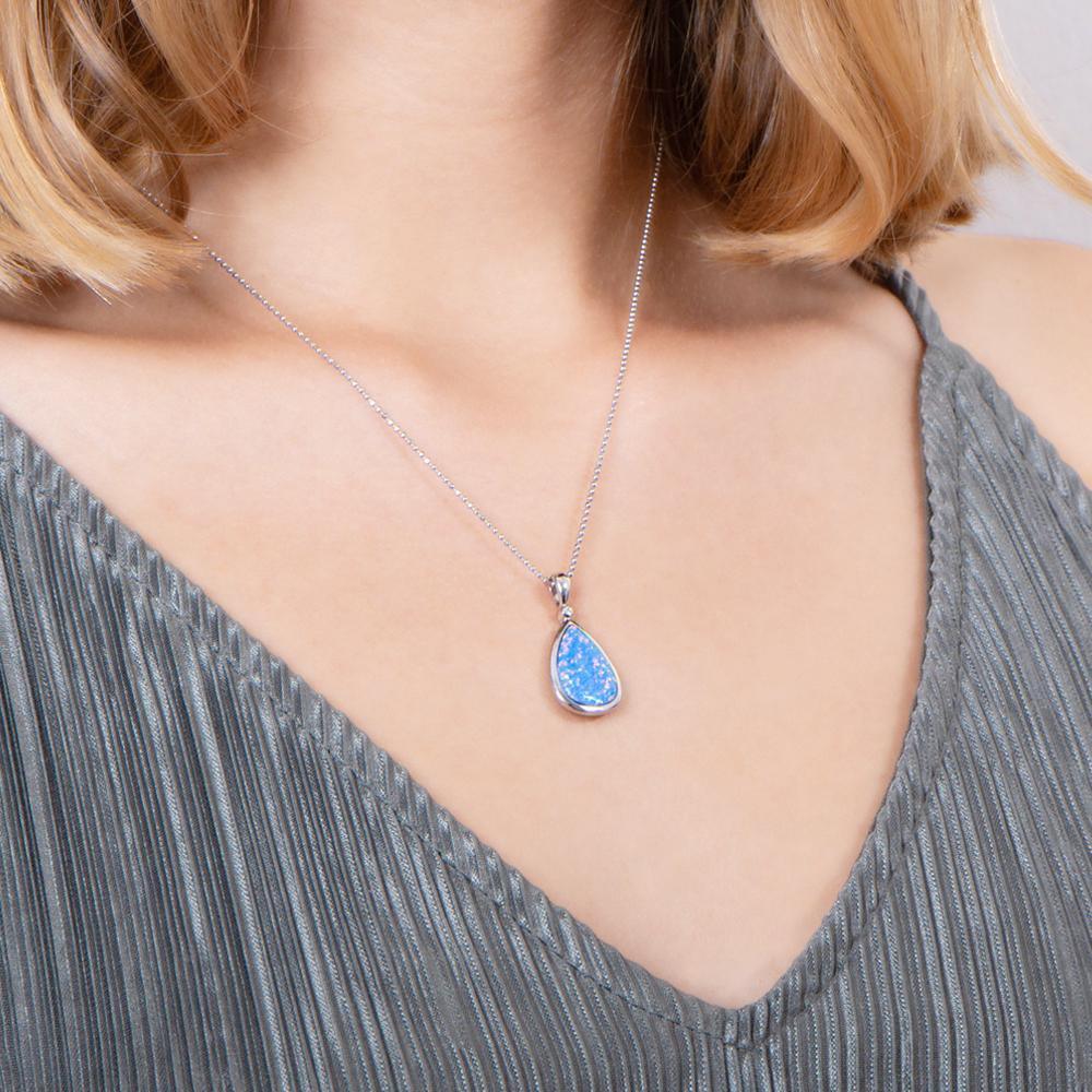 The picture shows a model wearing a 925 sterling silver opalite reuleaux teardrop pendant with cubic zirconia.