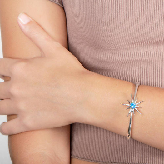 The picture shows a model wearing a 925 sterling silver opalite urchin star bangle.
