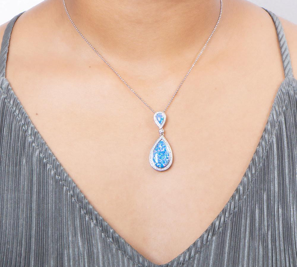 The picture shows a model wearing a 925 sterling silver opalite splash pendant with cubic zirconia.