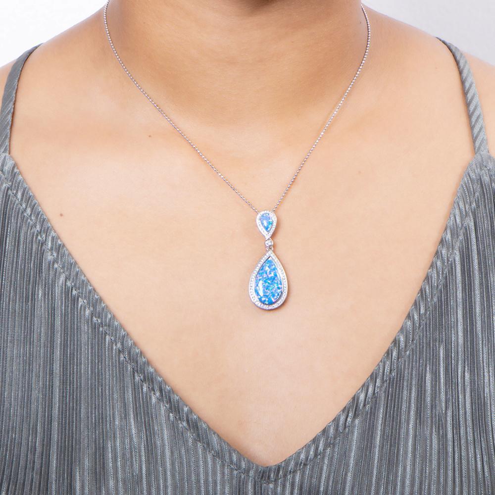 The picture shows a model wearing a 925 sterling silver opalite splash pendant with cubic zirconia.