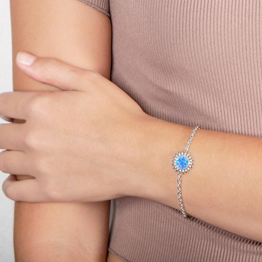 In this photo there is a model wearing a 925 sterling silver sunflower bracelet with one blue opalite gemstone