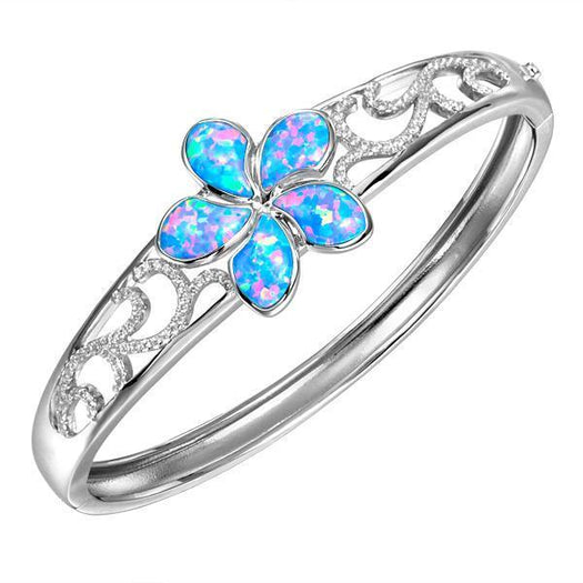 In this photo there is a 925 sterling silver plumeria bangle with blue opalite gemstones and cubic zirconia.