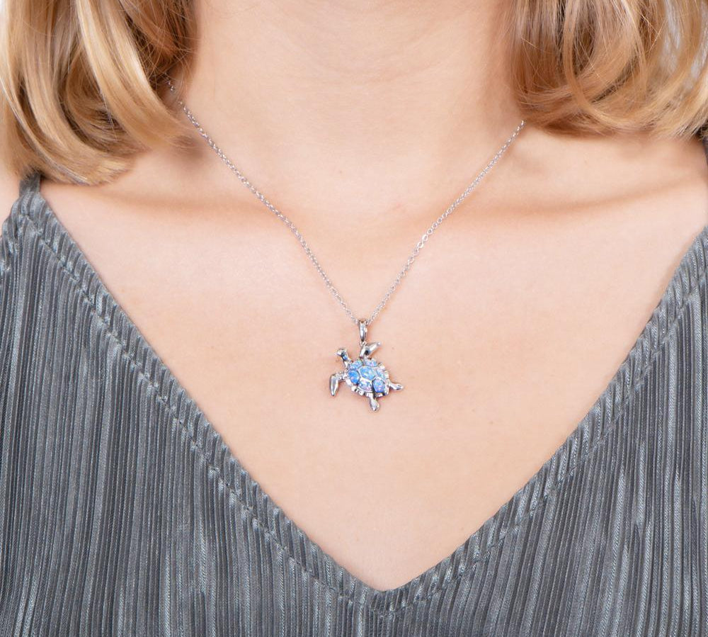 The picture shows a model wearing a 925 sterling silver opalite sea turtle pendant.