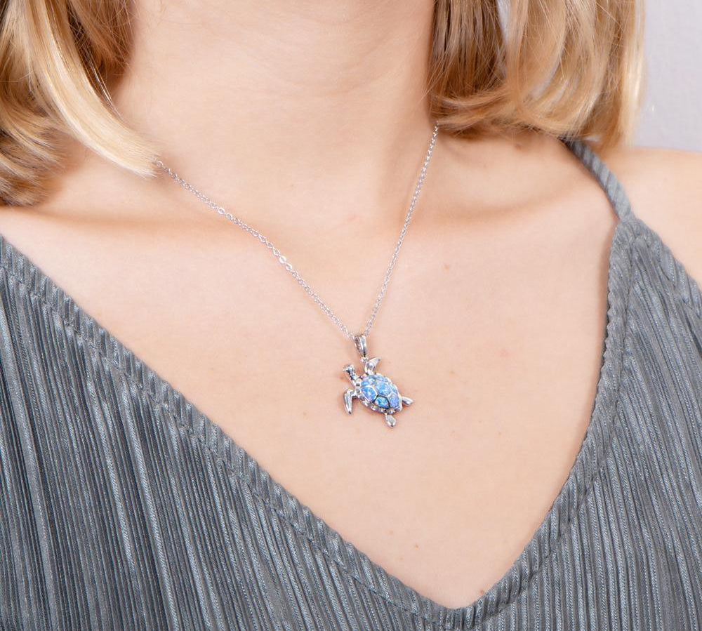 The picture shows a model wearing a 925 sterling silver opalite sea turtle pendant.