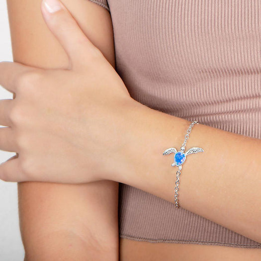 The picture shows a model wearing a 925 sterling silver opalite sea turtle bracelet.