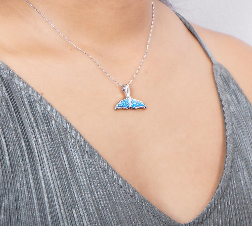 The picture shows a model wearing a 925 sterling silver opalite whale tail pendant.