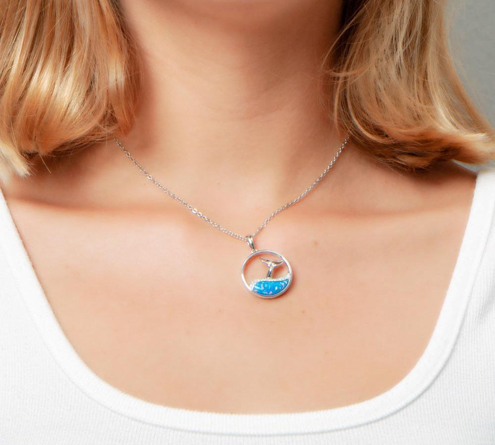 The picture shows a model wearing a 925 sterling silver opalite whale tail wave pendant with topaz.