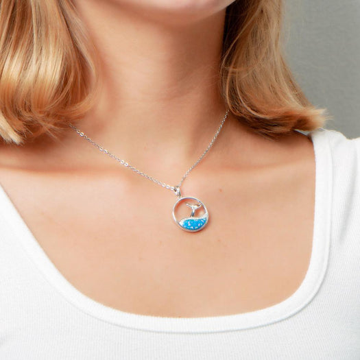 The picture shows a model wearing a 925 sterling silver opalite whale tail wave pendant with topaz.
