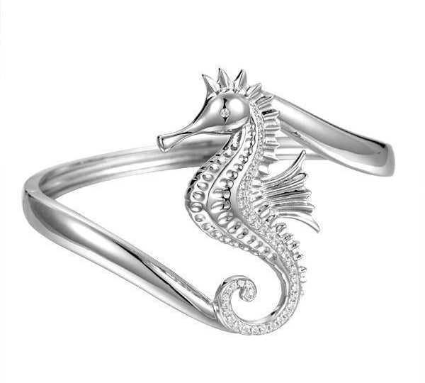 The picture shows a 925 sterling silver seahorse bangle with topaz.