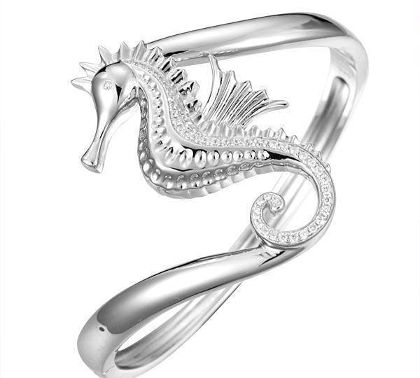 The picture shows a 925 sterling silver seahorse bangle with topaz.