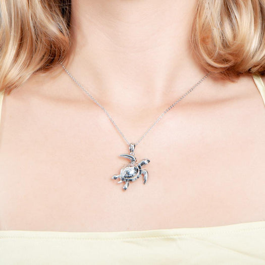The picture shows a model wearing a 925 sterling silver sea turtle pendant.