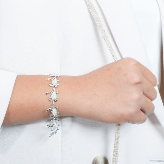 The picture shows a model wearing a 925 sterling silver white gold plated blue crab bracelet with topaz.
