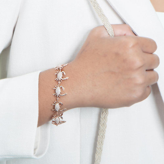 The picture shows a model wearing a 925 sterling silver rose gold plated blue crab bracelet with topaz.