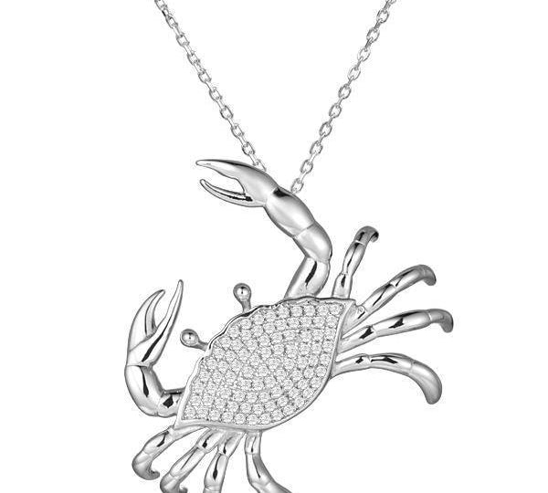 The picture shows a 925 sterling silver, white gold plated, pavé blue crab pendant with cubic zirconia.