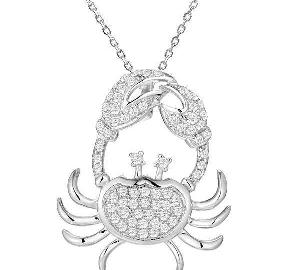 The picture shows a 925 sterling silver, white gold plated, pavé crab pendant with topaz.