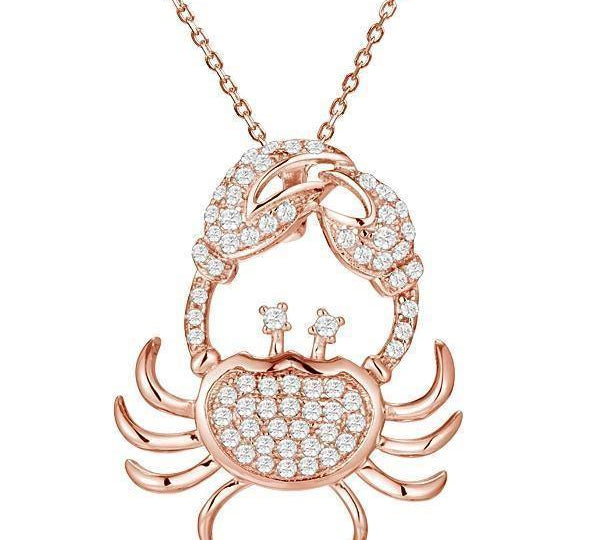 The picture shows a 925 sterling silver, rose gold plated, pavé crab pendant with topaz.