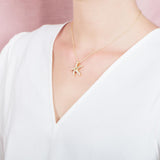 The picture shows a model wearing a 925 sterling silver, yellow gold plated, dancing starfish pendant with topaz.