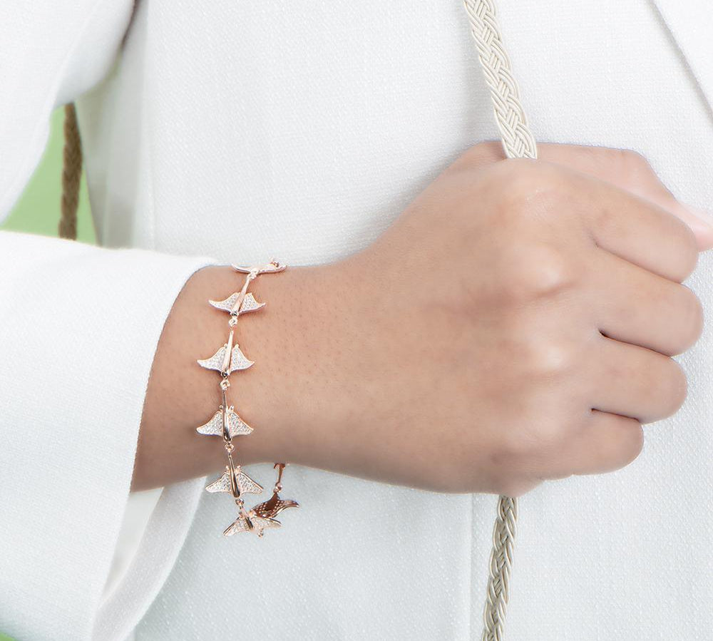 The picture shows a model wearing a 925 sterling silver rose gold-plated eagle ray bracelet with cubic zirconia.