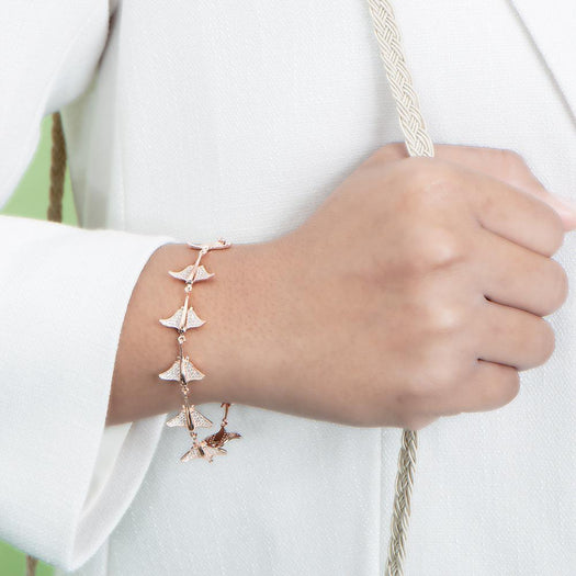 The picture shows a model wearing a 925 sterling silver rose gold-plated eagle ray bracelet with cubic zirconia.