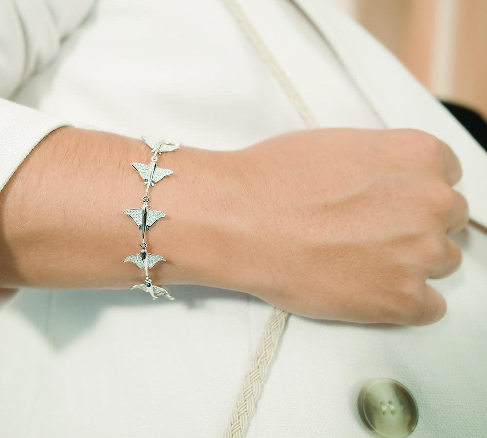 The picture shows a model wearing a 925 sterling silver white gold-plated eagle ray bracelet with cubic zirconia.