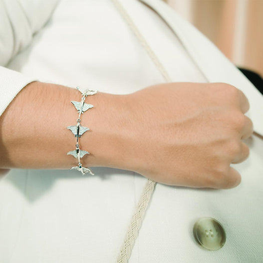 The picture shows a model wearing a 925 sterling silver white gold-plated eagle ray bracelet with cubic zirconia.