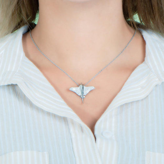 The picture shows a model wearing a 925 sterling silver, white gold plated, pavé eagle ray pendant with cubic zirconia.