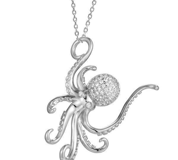 The picture shows a 925 sterling silver, white gold vermeil, pavé octopus pendant with topaz.