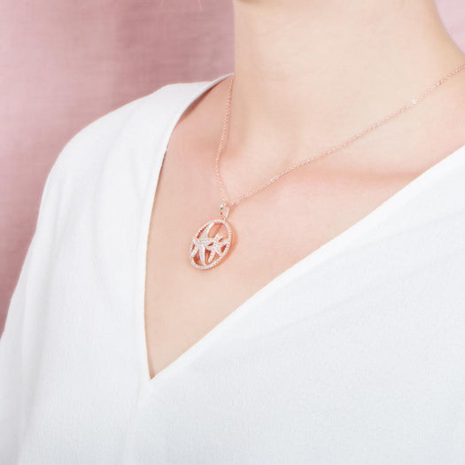 The picture shows a model wearing a 925 sterling silver, rose gold vermeil, double starfish circle pendant with topaz.