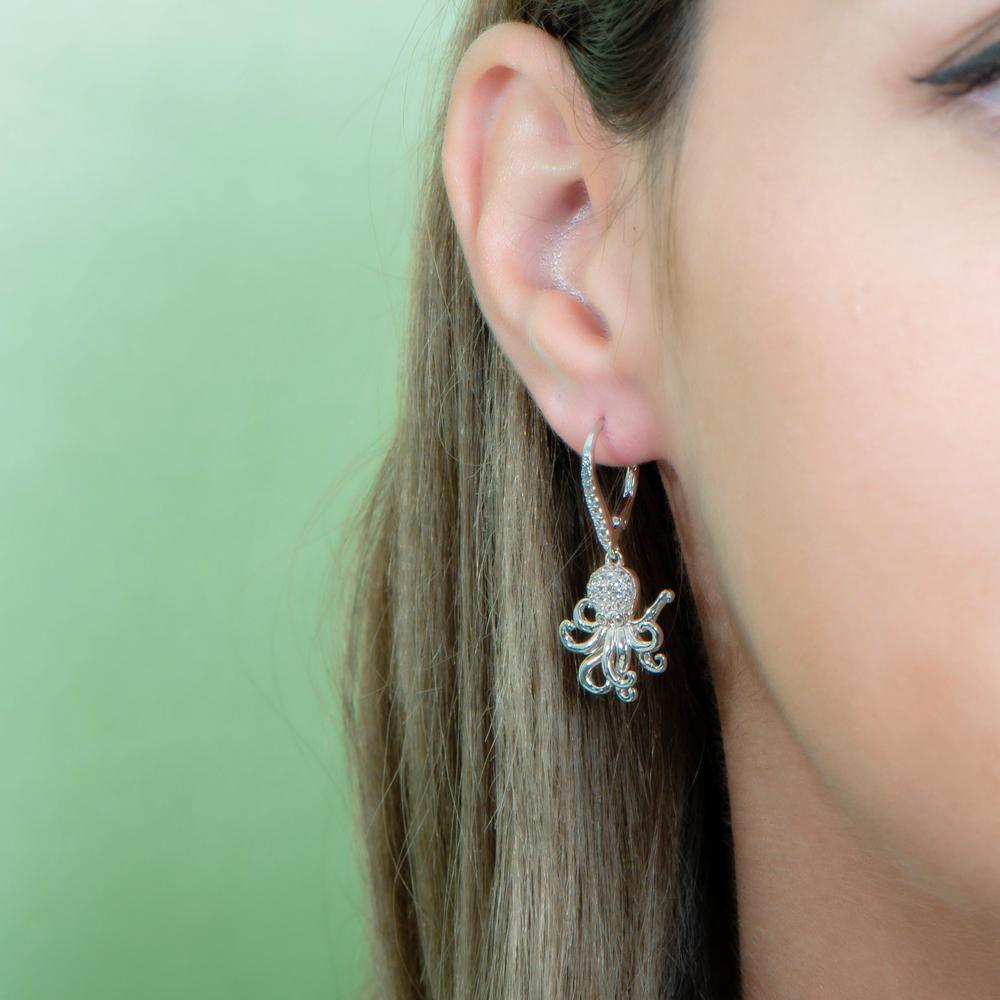 The picture shows a model wearing a 925 sterling silver octopus earring with topaz.