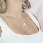 The picture shows a model wearing a 925 sterling silver pavé larimar sea turtle pendant with cubic zirconia.