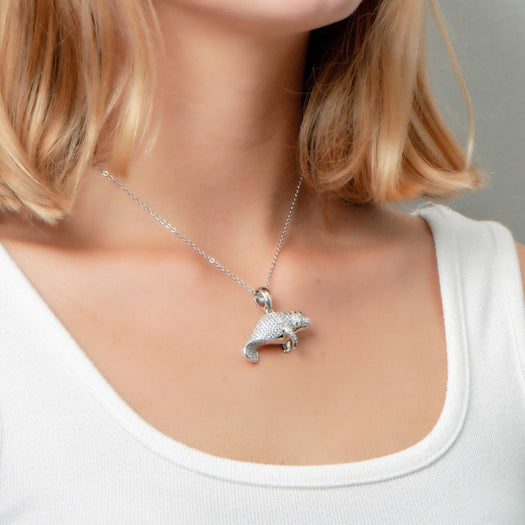 The picture shows a model wearing a 925 sterling silver pavé manatee pendant with cubic zirconia.