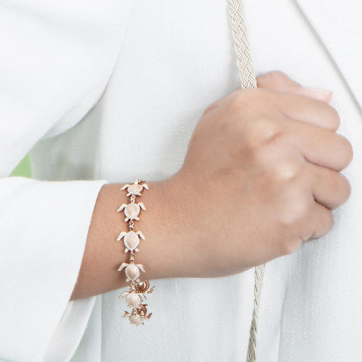 The picture shows a model wearing a 925 sterling silver rose gold-plated sea turtle bracelet with cubic zirconia.