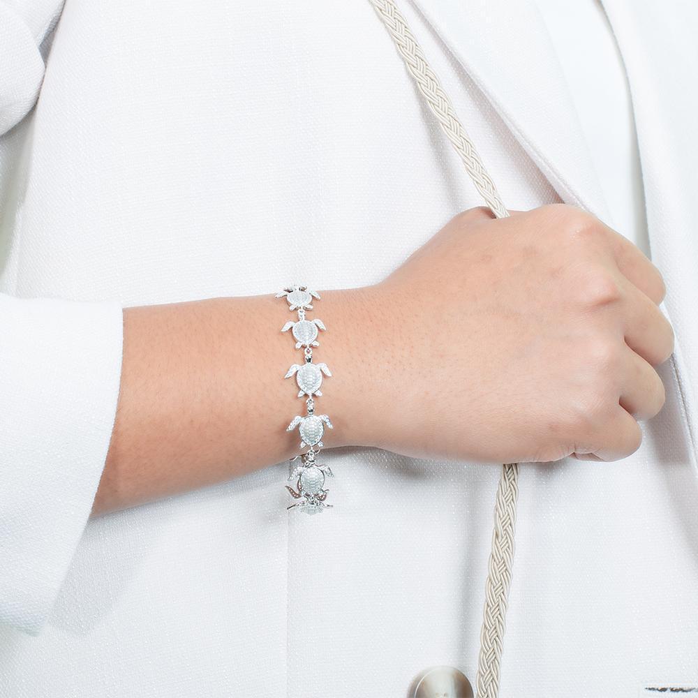 The picture shows a model wearing a 925 sterling silver white gold-plated sea turtle bracelet with cubic zirconia.