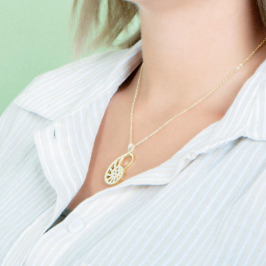 The picture shows a model wearing a 925 sterling silver pavé yellow gold vermeil nautilus shell pendant with topaz.
