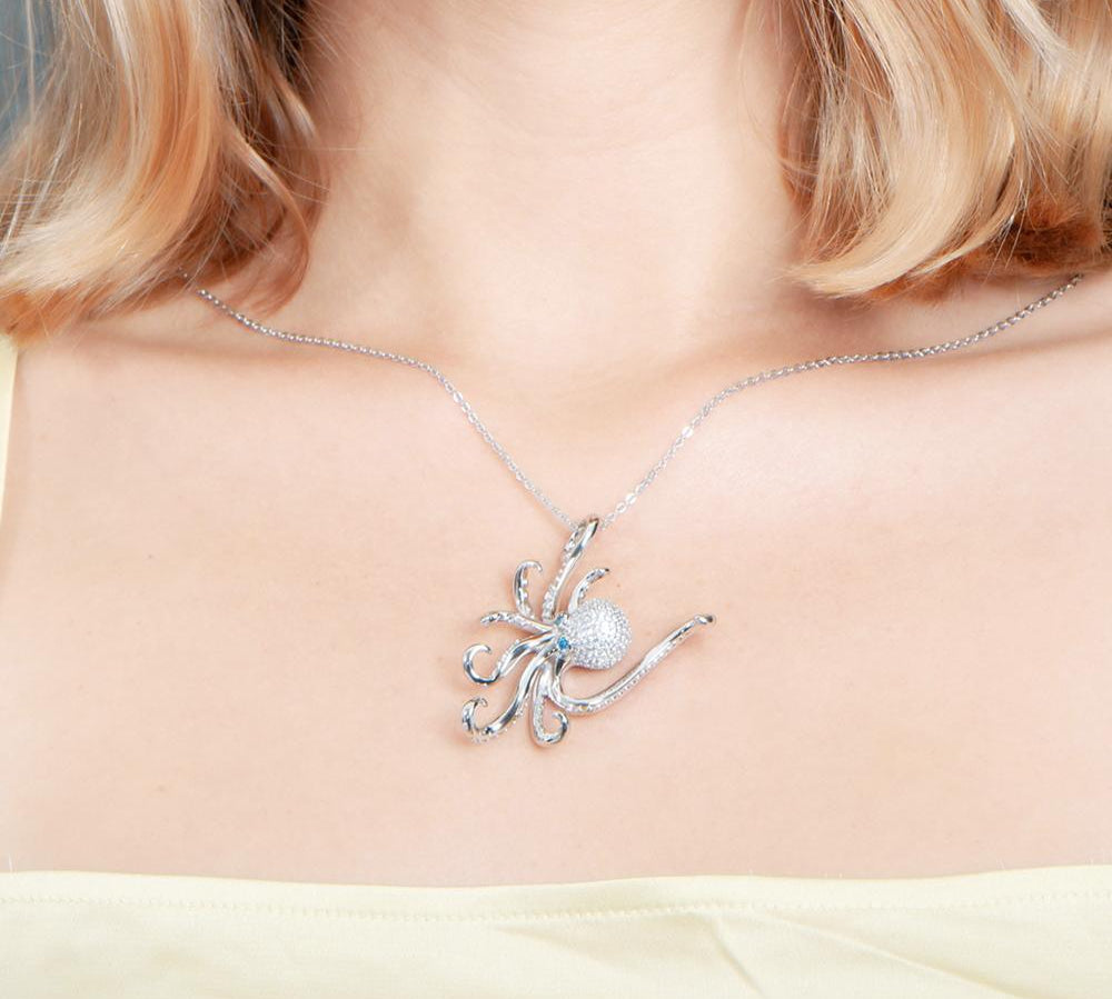 The picture shows a model wearing a 925 sterling silver pavé octopus pendant with topaz.