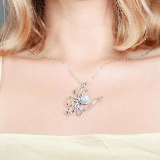 The picture shows a model wearing a 925 sterling silver pavé octopus pendant with topaz.