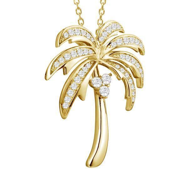 In this photo there is a yellow gold palm tree pendant with topaz gemstones.