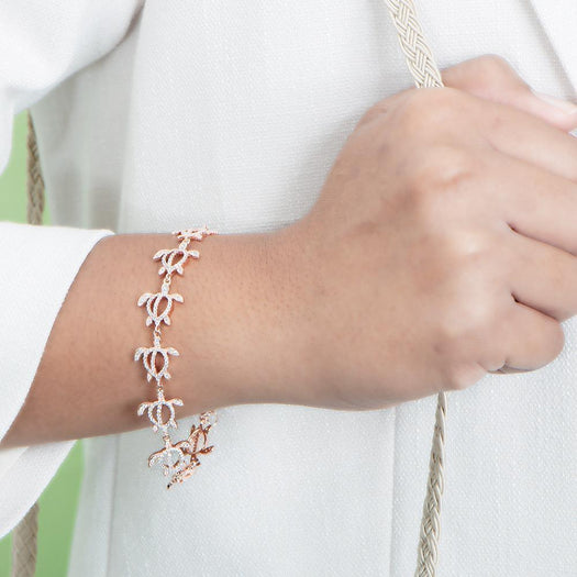 The photo shows a model wearing a 925 sterling silver rose gold-plated Polynesian sea turtle bracelet with topaz.