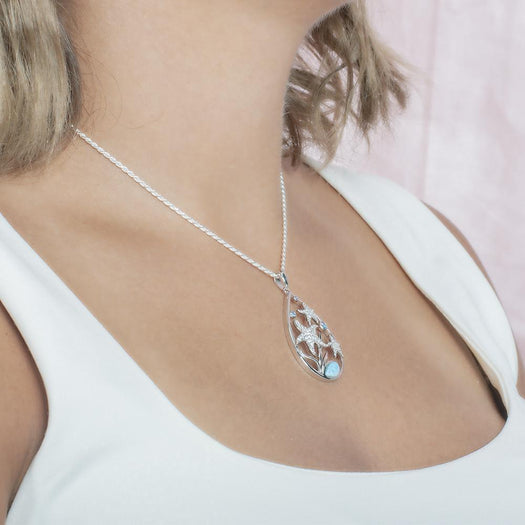 The picture shows a model wearing a 925 sterling silver teardrop three sea star pendant, with larimar gemstone, aquamarine, and topaz.