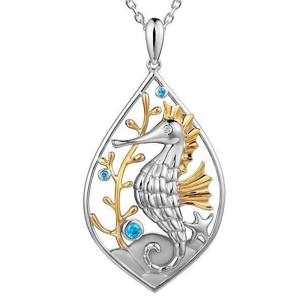 The picture shows a two-tone white and yellow gold sea horse mandorla pendant with aquamarine and topaz.