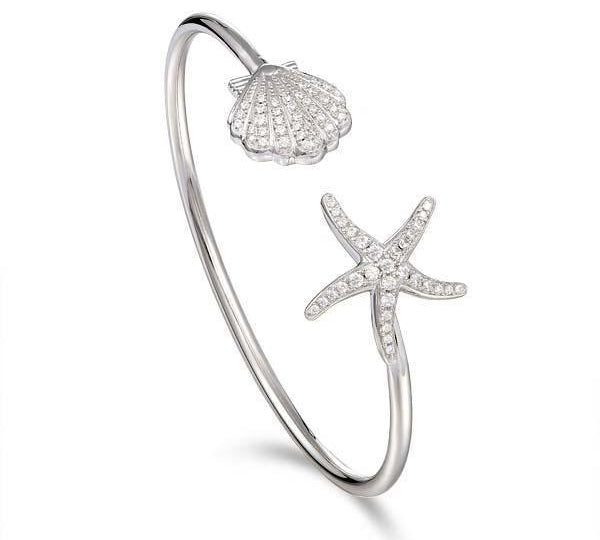 The picture shows a 925 sterling silver starfish and oyster bangle with topaz.