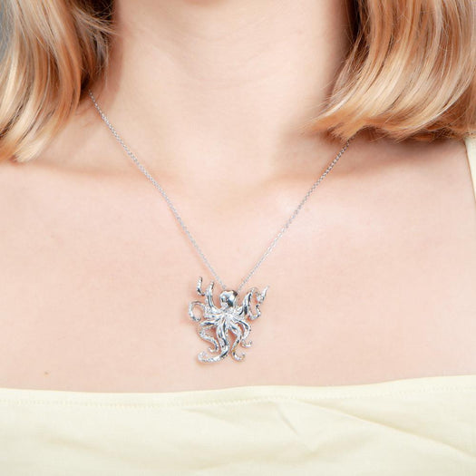 The picture shows a model wearing a 925 sterling silver swimming octopus pendant with topaz.