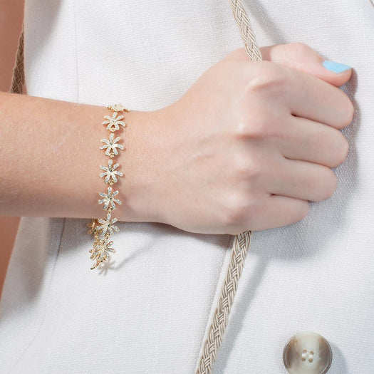 In this photo there is a model wearing a yellow gold tiare gardenia bracelet with topaz gemstones.