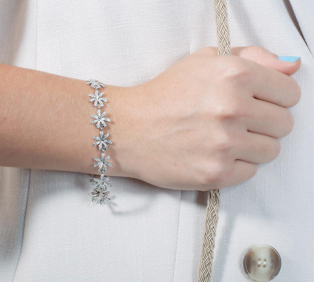 In this photo there is a model wearing a white gold tiare gardenia bracelet with topaz gemstones