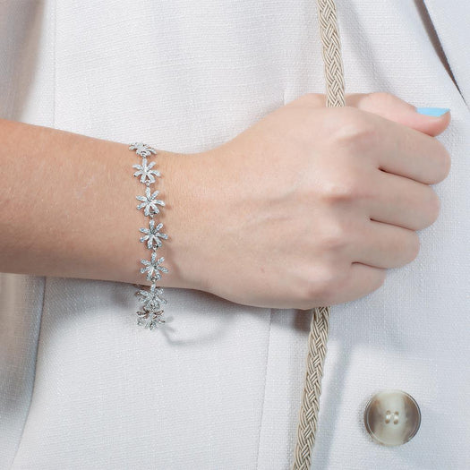 In this photo there is a model wearing a white gold tiare gardenia bracelet with topaz gemstones