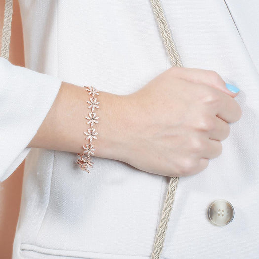 In this photo there is a model wearing a rose gold tiare gardenia bracelet with topaz gemstones.